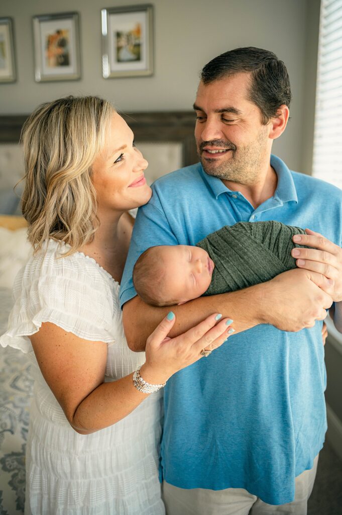A Houston couple hold their newborn son during colorful family photos in their home 
