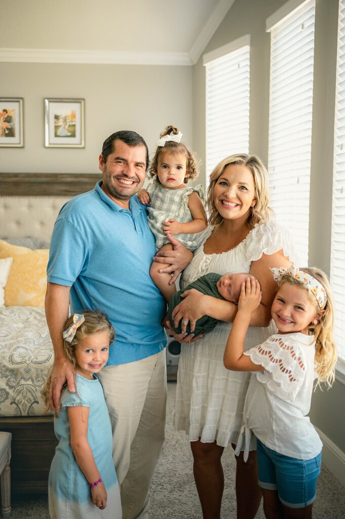 A family of 6 poses for colorful family photos in their Houston TX home 