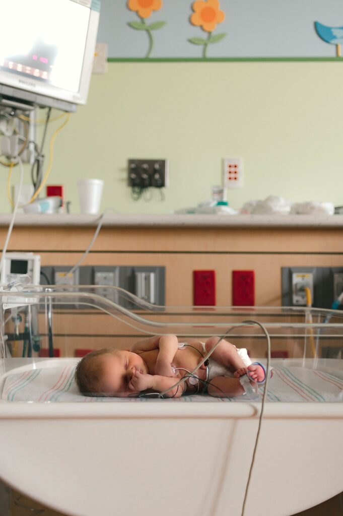 A newborn is photographed at a Houston NICU during a fresh 48 newborn photoshoot