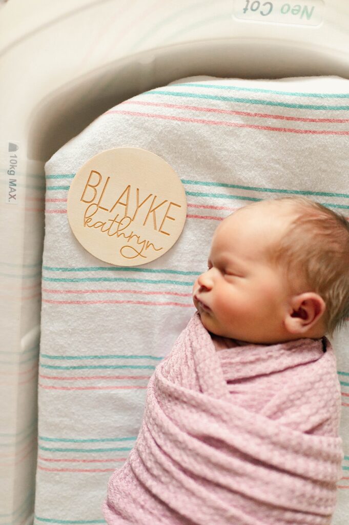 A baby girl in a pink swaddle is photographed at a Houston hospital during a fresh 48 newborn session