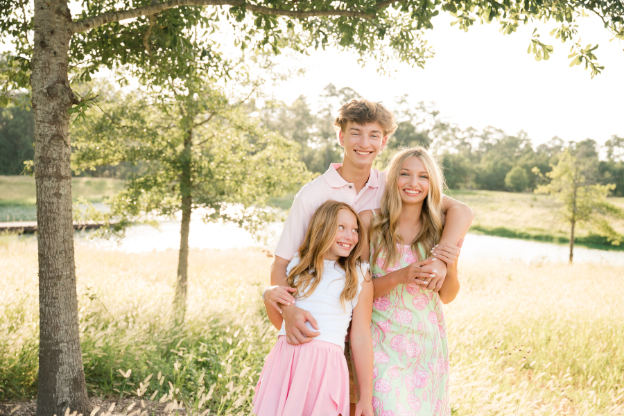 Three blonde siblings laugh in an image captured by a family photographer cypress tx.