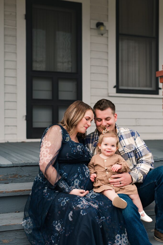 A family and maternity photoshoot is captured on the porch of a quaint home in Cypress TX. 