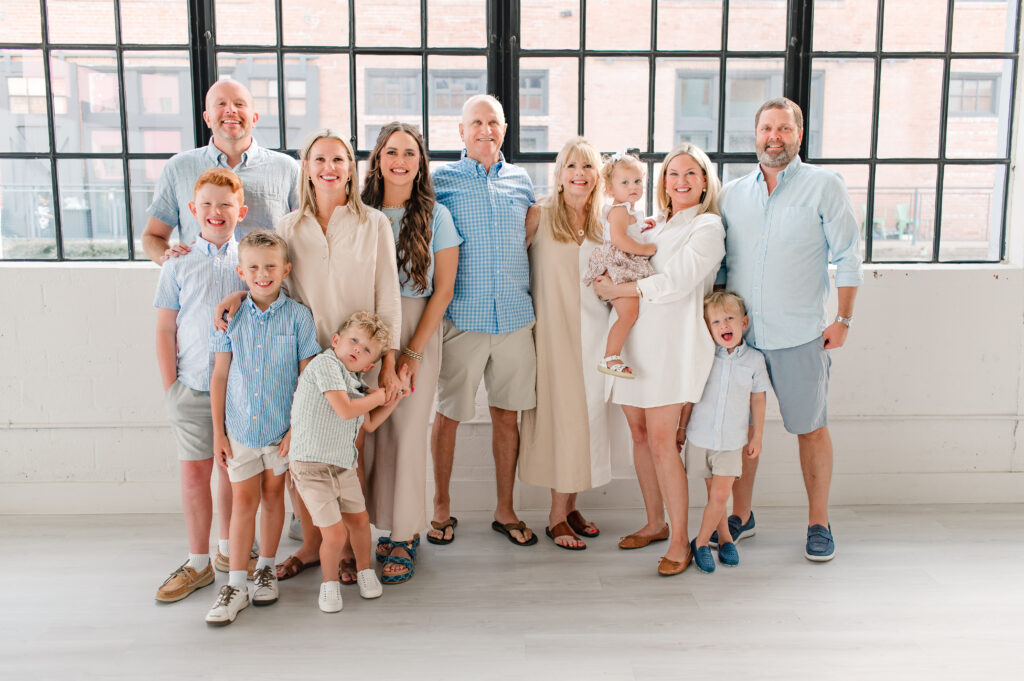 An extended family session in a Houston area studio is depicted as an example of how to plan your family photos wardrobe by Mel B Photography.  This family opted for clothing pieces in shades of blue and tan, often alternating the colors in pants & tops.