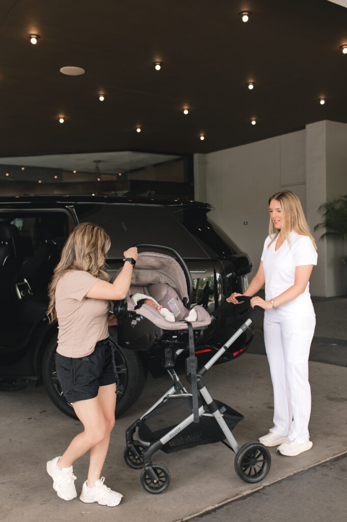 A mother is assisted by staff from The Ruby Postnatal with her stroller 