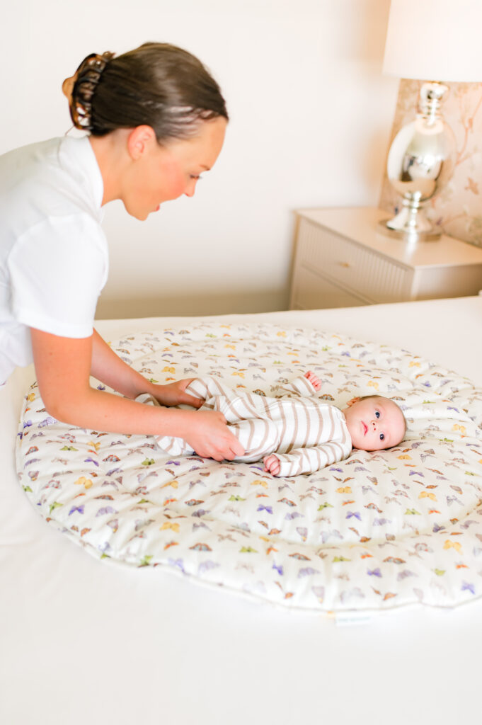 A newborn is photographed on a butterfly playmat by Fort Weekend 