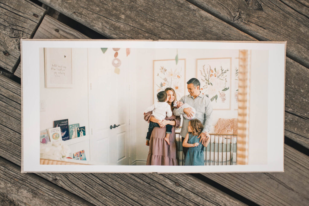 A family of five is photographed in a nursery from Houston family photos in a photo album spread created by mel b photo