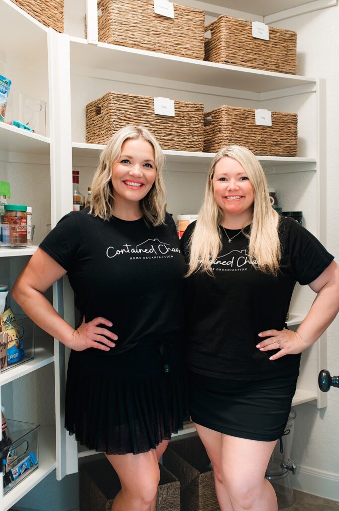 Professional organizers in Houston TX pose in front of a pantry they organized in collaboration with in-home Houston newborn photographer, Mel B Photo