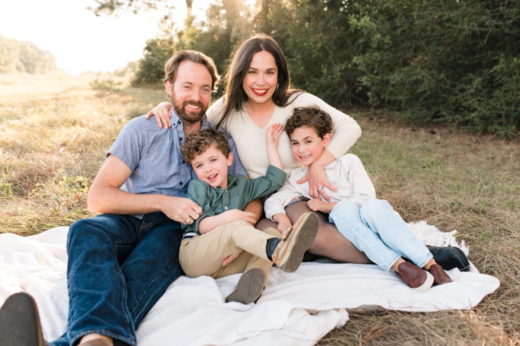 A family of four poses on a blanket at Cy Hope, one of a local photographers favorite places to take photos in Houston