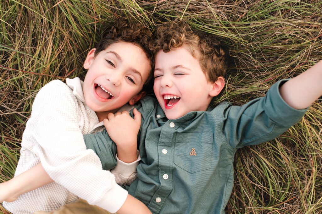 Two brothers laugh in the grass at Cy Hope, one of the best photo locations in Houston