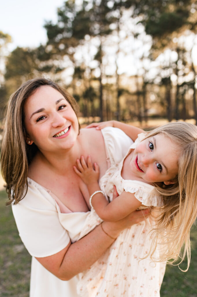 A mother and her young daughter lean into the  camera in an image taken at a Houston photo session at Mary Jo Peckham Park 