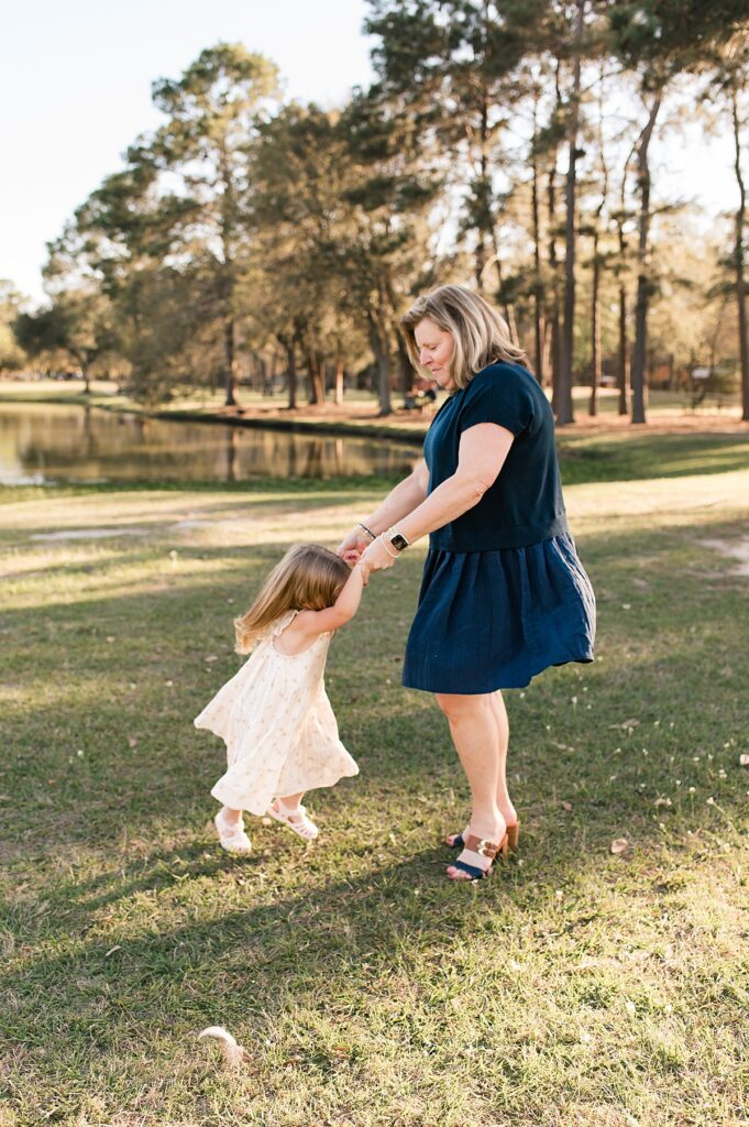 A woman swings a little girl during a session for family photography in Cypress TX 