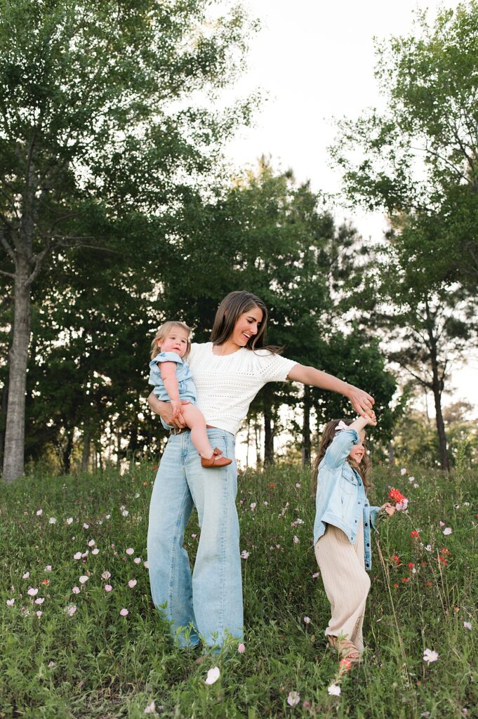 A mother twirls her daughter during outdoor family photos Houston TX