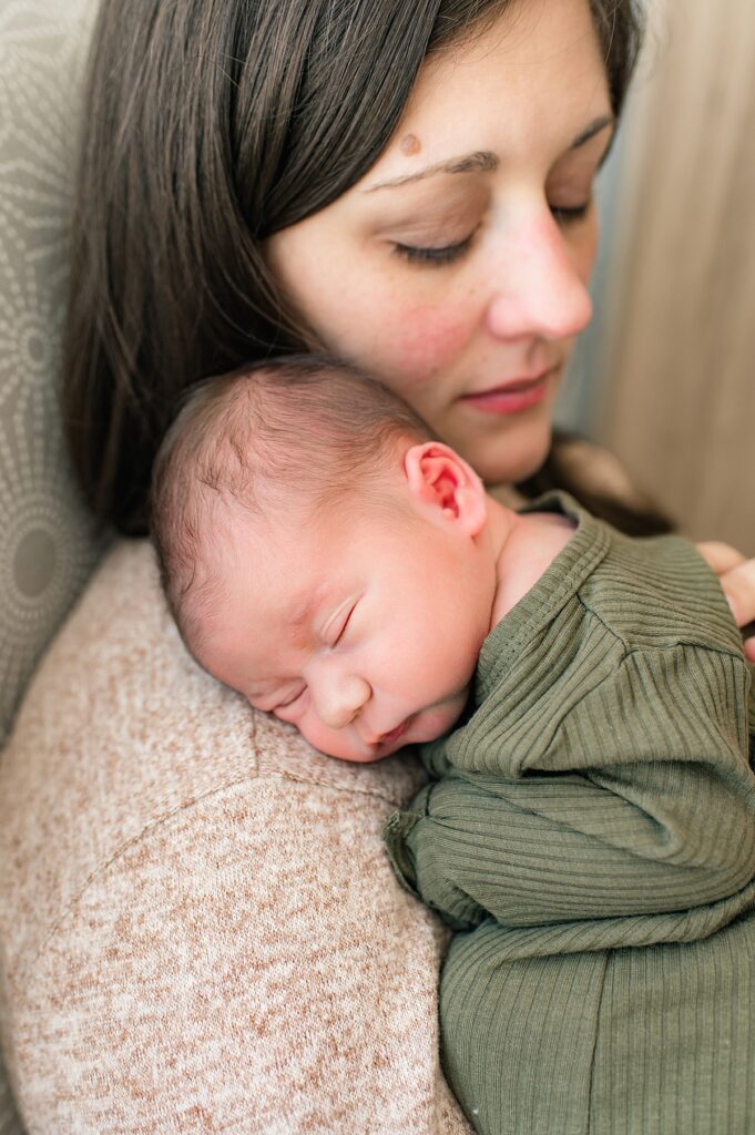 A mother holds her newborn in a phot taken during a houston texas fresh 48 photoshoot 