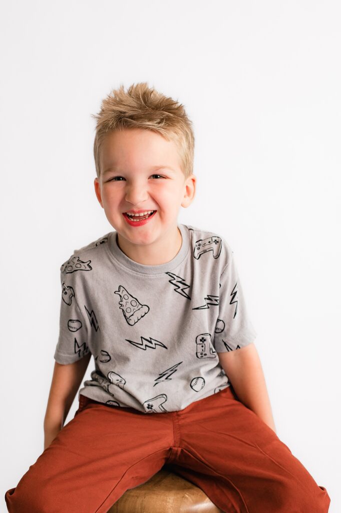 A young boy smiles in school portrait photography in Houston TX