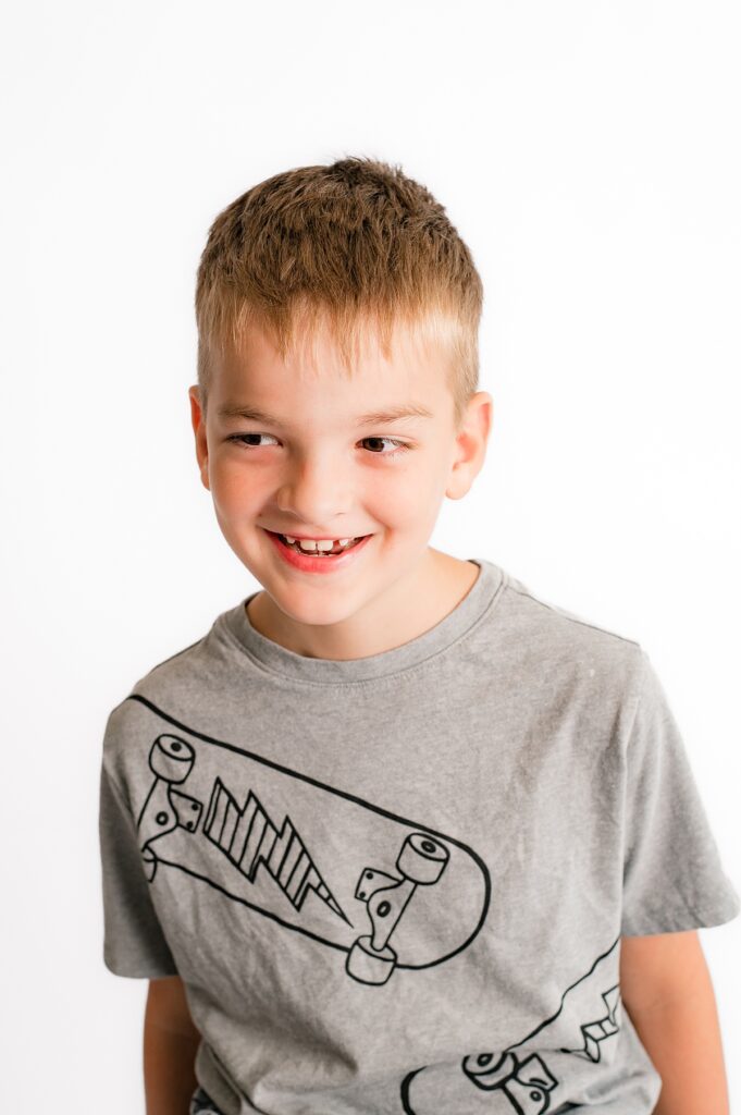 A young boy smiles in one of the images from his Houston portraits session