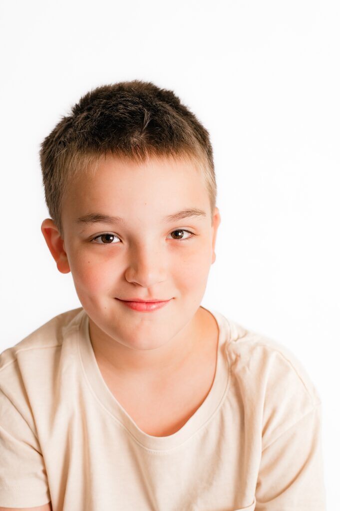 Houston portraits showcase a young boy smiling before a white background