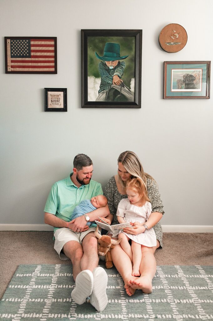 A mother and father are seated with their toddler and newborn in the floor of the vintage themed nursery taken by Houston TX newborn photographer, Mel B Photo