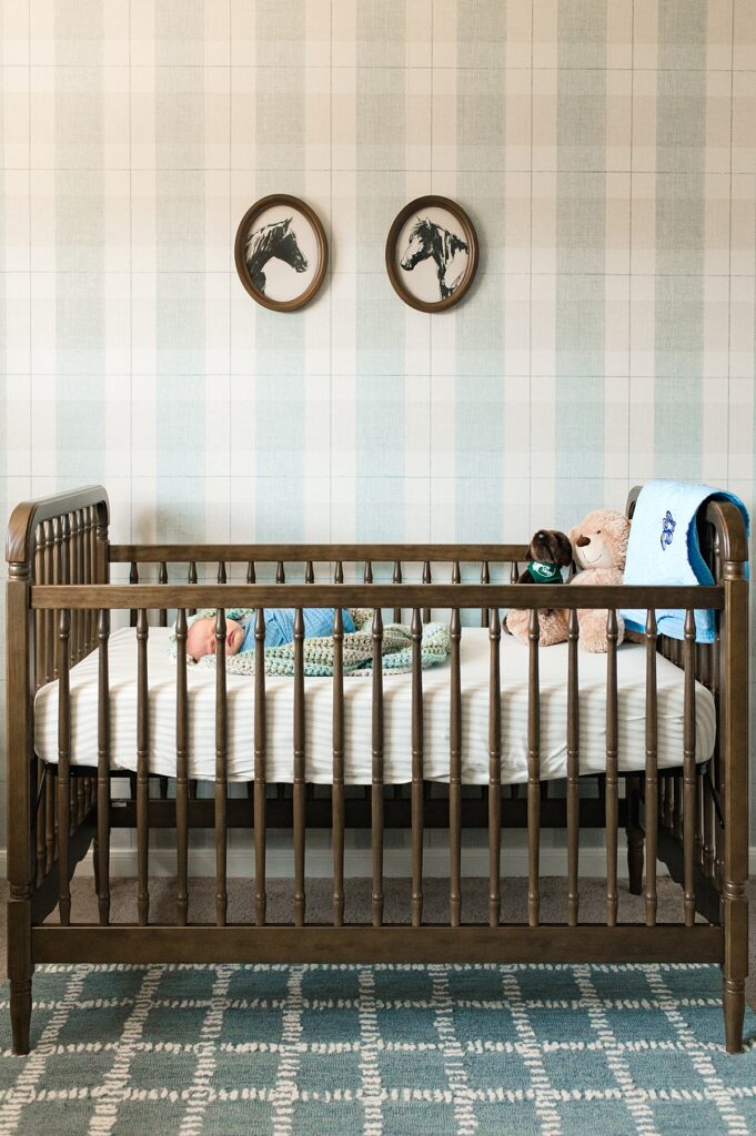 A newborn baby boy sleeps in his crib in his vintage western themed nursery during a Houston newborn photo session