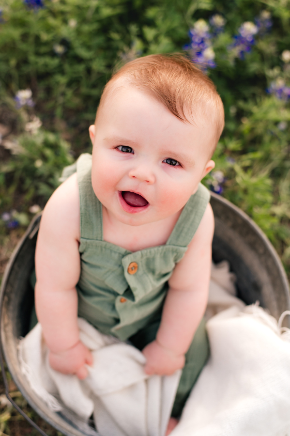 A baby smiles up for bluebonnet brenham tx photos