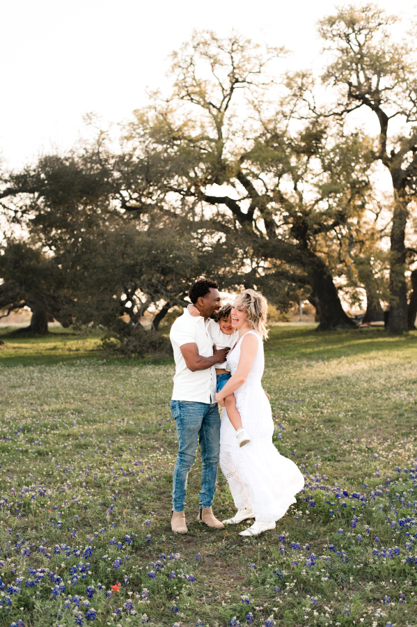 A family of three pose for family bluebonnet photos texas