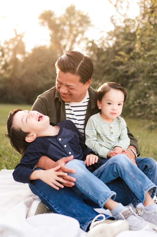 A father laughs with his two young sons in a photo  captured by Cypress Family Photographer, Mel B photo, in the Bridgeland community