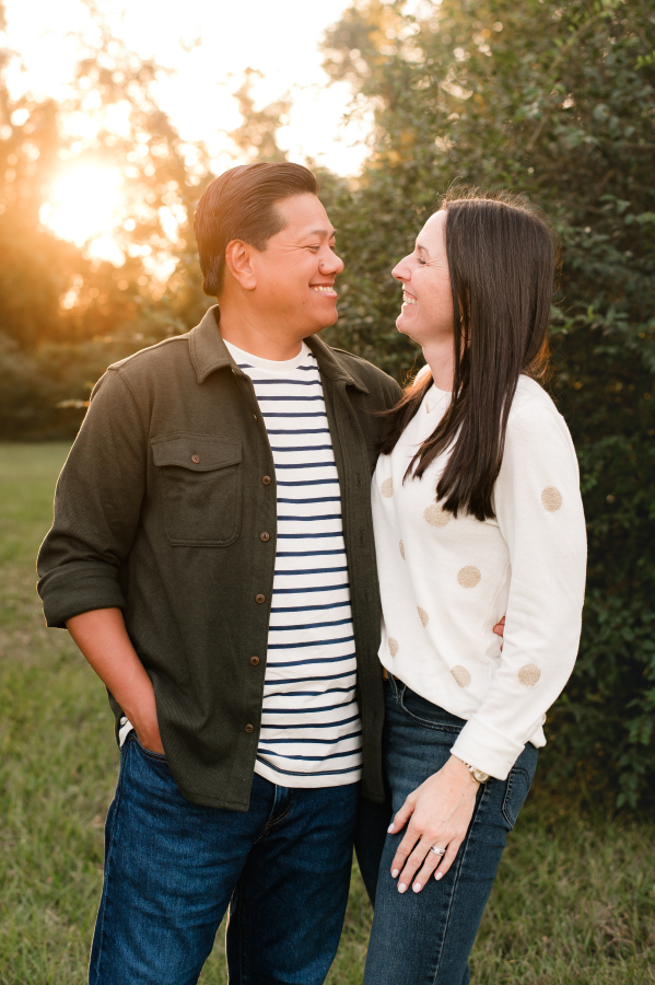 A Cypress Texas couple smile at each other in a photo taken at a Bridgeland community park 