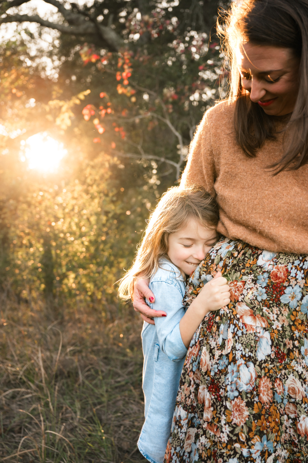 A young girl hugs her mother in a photo taken by a Houston family photographer. 