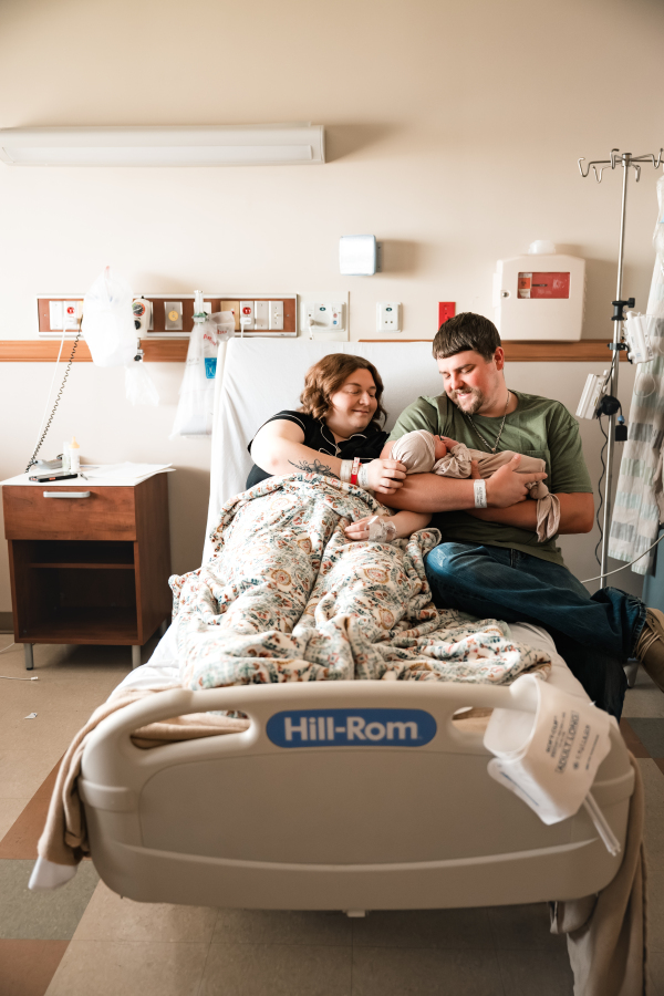 A mother and father smile down at their new baby in the maternity suite at a Houston Texas hospital