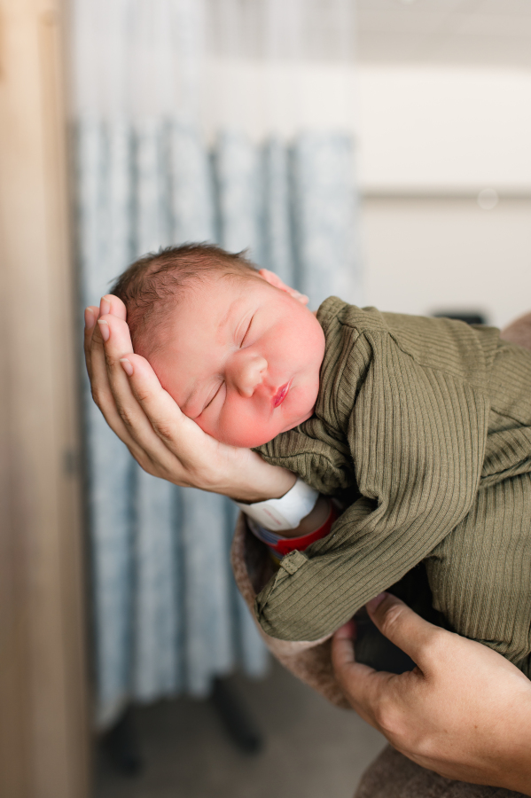 A newborn baby is photographed during a Houston Fresh 48 session at a Houston TX hospital