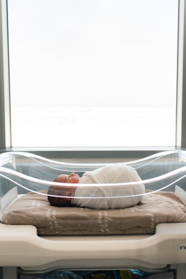 A baby is photographed in the hospital room bassinette during a Fresh 48 photoshoot with a Houston Newborn photographer