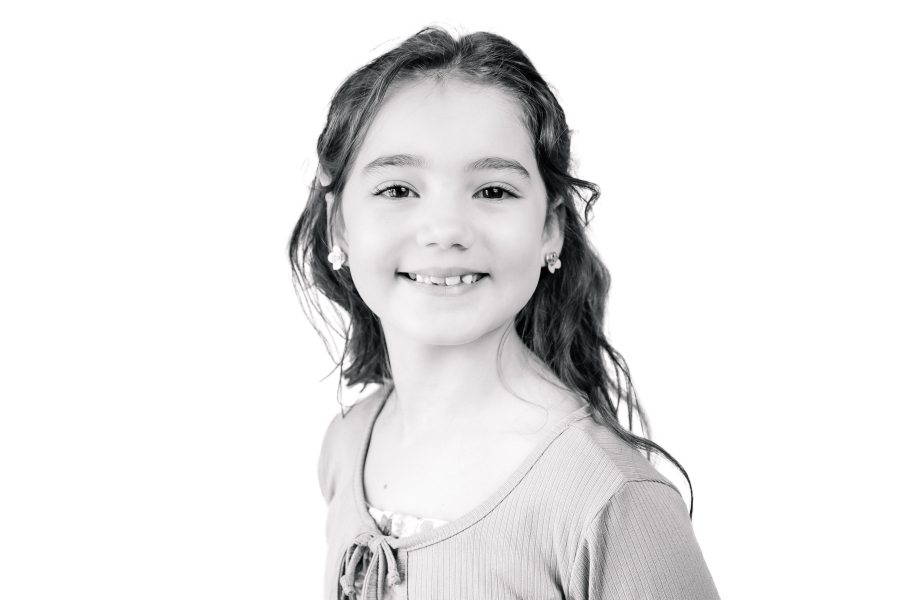 A black and white modern school portrait showcases a young girl smiling for Houston school portraits.