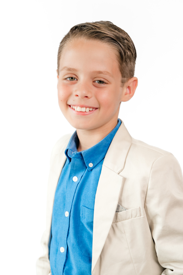 A young boy is dressed up for modern school portraits taken by a Houston school photographer.