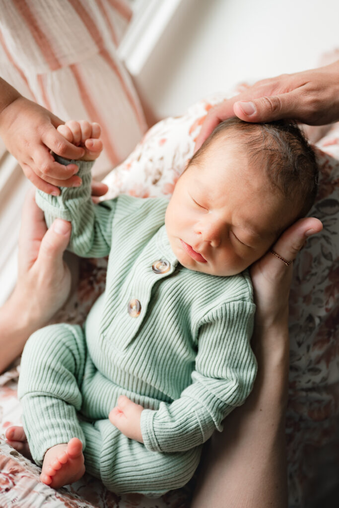 A newborn baby boy is captured in a close-up image depicting newborn poses for photography sessions in the home. 