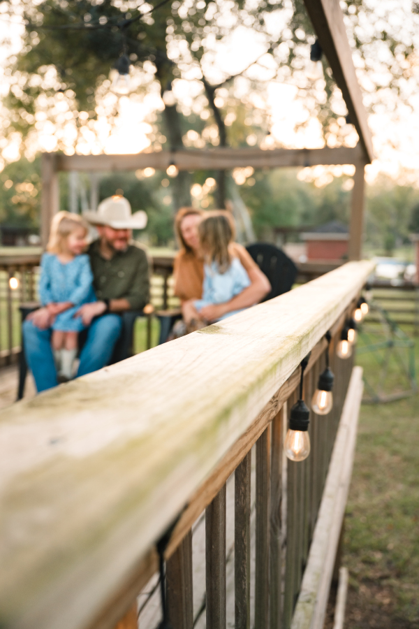A family of four poses on their back porch during an in-home family photoshoot in Houston.