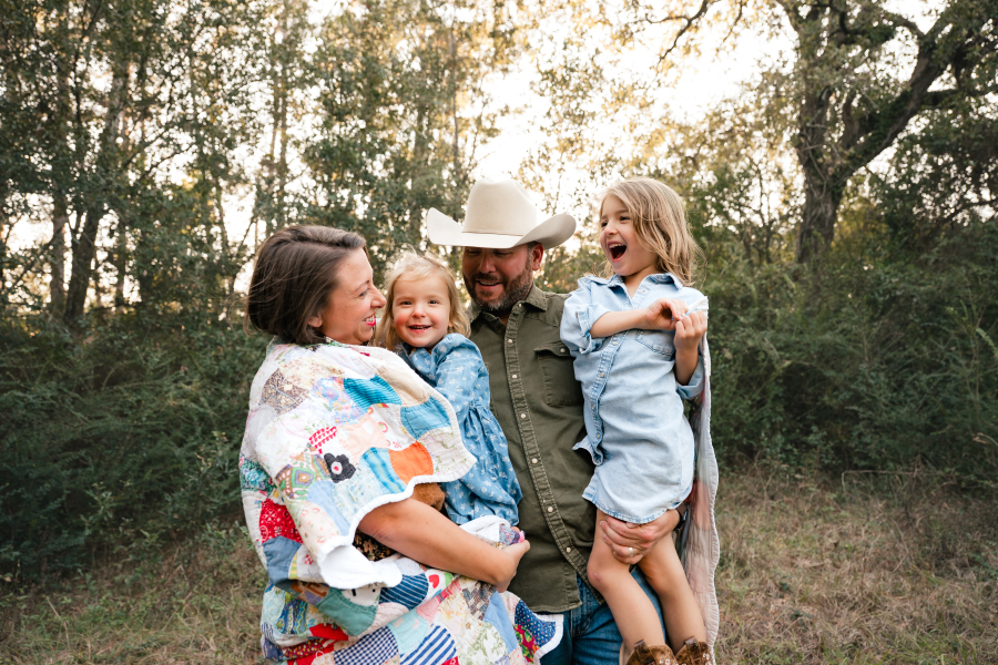 A young couple smile at their two daughters during a photoshoot with a Houston lifestyle photographer.